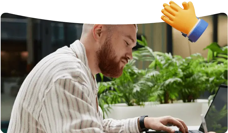 A clapping hands icon over a man working on his computer